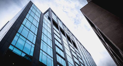 Low angle view of glass building against sky