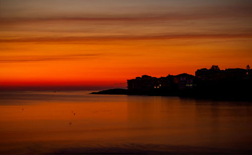 Scenic view of sea against romantic sky at sunset