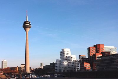 Modern buildings in city against clear blue sky