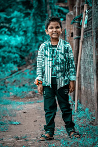 Portrait of smiling young man standing against plants