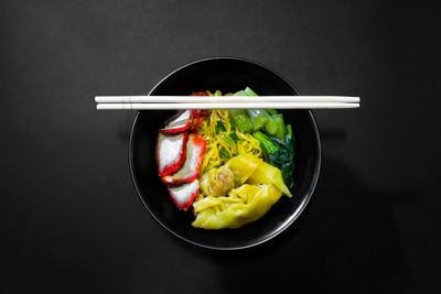 Directly above shot of food in bowl against black background