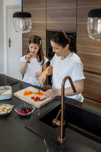 Woman standing on table at kitchen