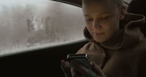 Portrait of mature man using mobile phone in car