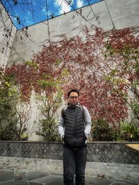 Portrait of young man standing against plants