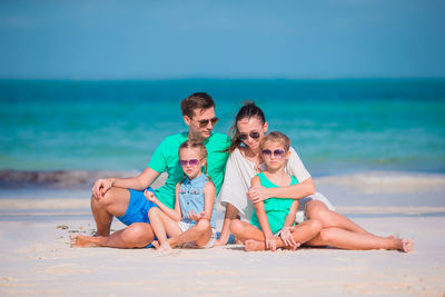 Portrait of friends on beach against sky