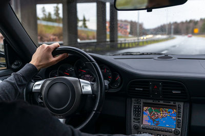 Man drives a car. car interior. steering wheel, shift lever, dashboard. view from the back seat.