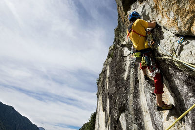 Low angle view of man rock climbing