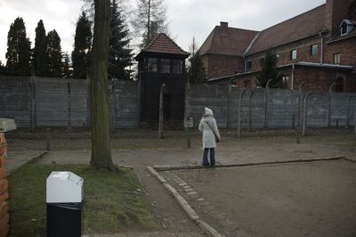 Rear view of woman walking by building