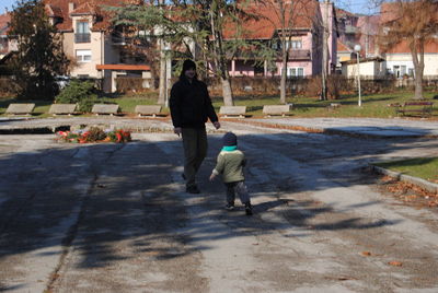 Rear view of people walking on street in city