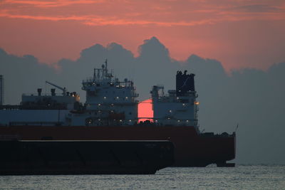 Scenic view of sea and a ship against sky during sunset