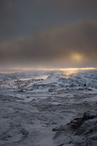 Scenic view of frozen sea against dramatic sky