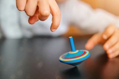 Midsection of child spinning a whirligig 