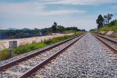 Railway tracks on landscape against sky