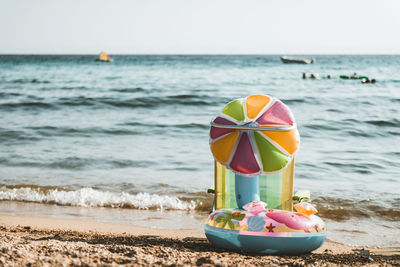 Toy on beach against sky