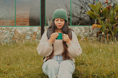 Portrait of young woman sitting on field