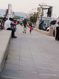 People on footpath in city