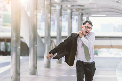 Mid adult businessman yawning while walking at elevated walkway