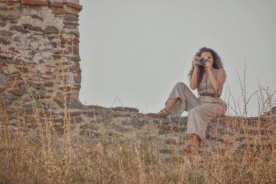 Woman standing on field against clear sky