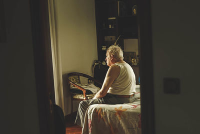 Old man sitting on a bed