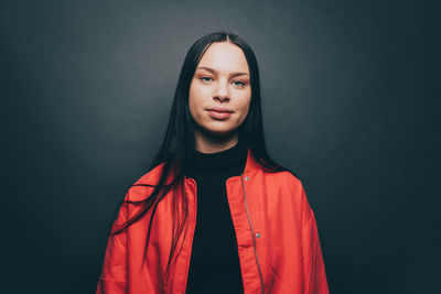 Portrait of beautiful young woman against black background