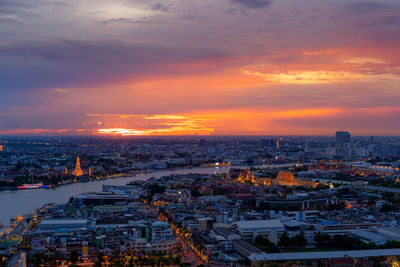 High angle view of illuminated cityscape against sky during sunset