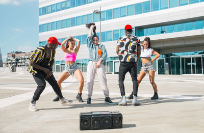 Friends dancing against building in city