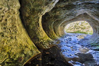 Rock formation by river in tunnel