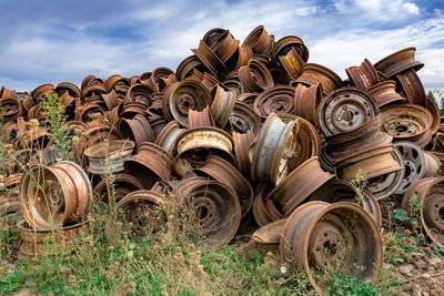 Stack of old fashioned in field against sky