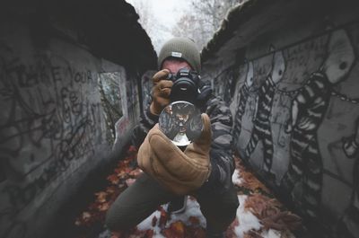 Full length of man photographing while standing at alley