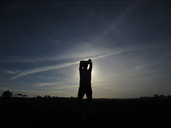 Silhouette of woman standing on field