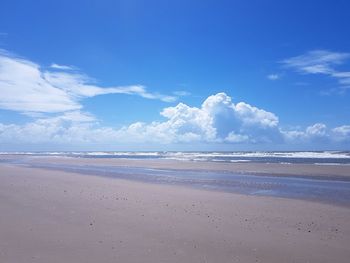 Scenic view of beach against blue sky