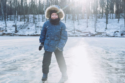 Winter holidays in nature. boy walks on ice. frozen lake on the background of the forest. 