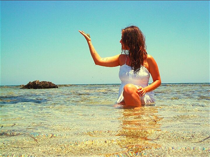 water, sea, leisure activity, lifestyles, full length, young adult, young women, beach, enjoyment, vacations, person, shore, bikini, horizon over water, arms raised, fun, arms outstretched, clear sky