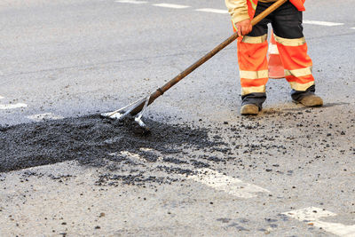 Low section of construction worker working on road