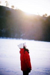 Person standing on snow covered mountain against sky