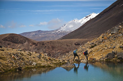 Side view of hikers walking on landscape