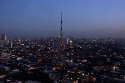 Illuminated buildings in city against sky