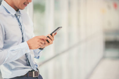 Midsection of man using mobile phone