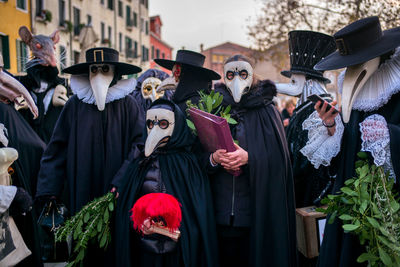 People in halloween costumes standing on street