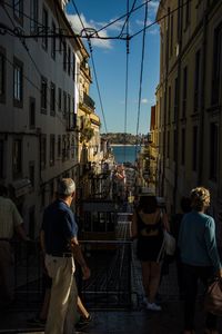 Rear view of people walking on city street