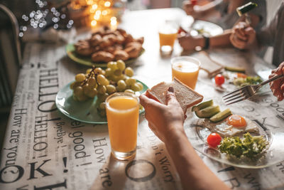 Cropped hand of woman eating breakfast