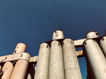 Low angle view of storage tanks against sky