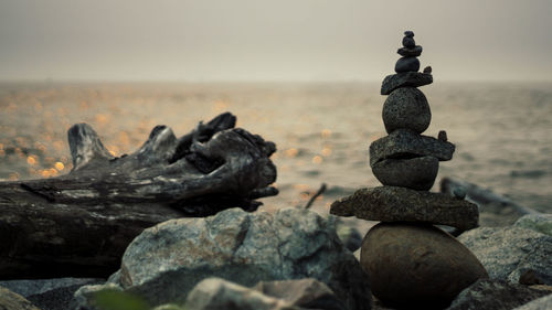 Stack of pebbles on beach against sky