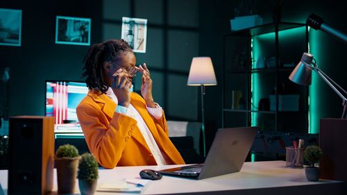 Side view of young woman using mobile phone in cafe