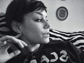 Close-up portrait of young man lying on bed at home