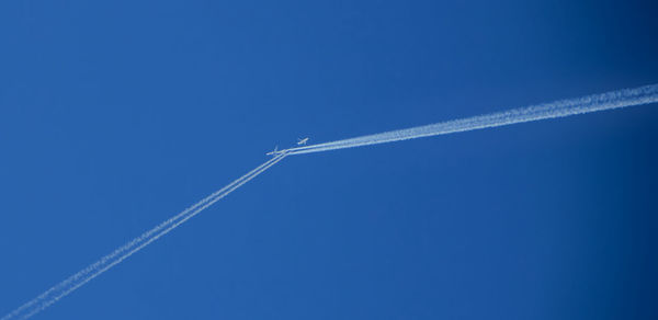 Low angle view of vapor trail against blue sky