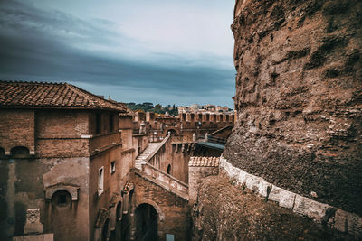 Low angle view of buildings against cloudy sky