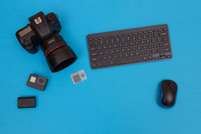 High angle view of computer keyboard on blue table