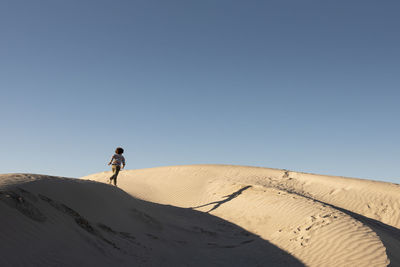 One kid runs on the ridge of a dune at dunas de la soledad