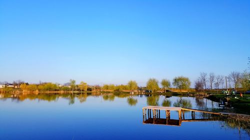 Reflection of trees in lake against blue sky